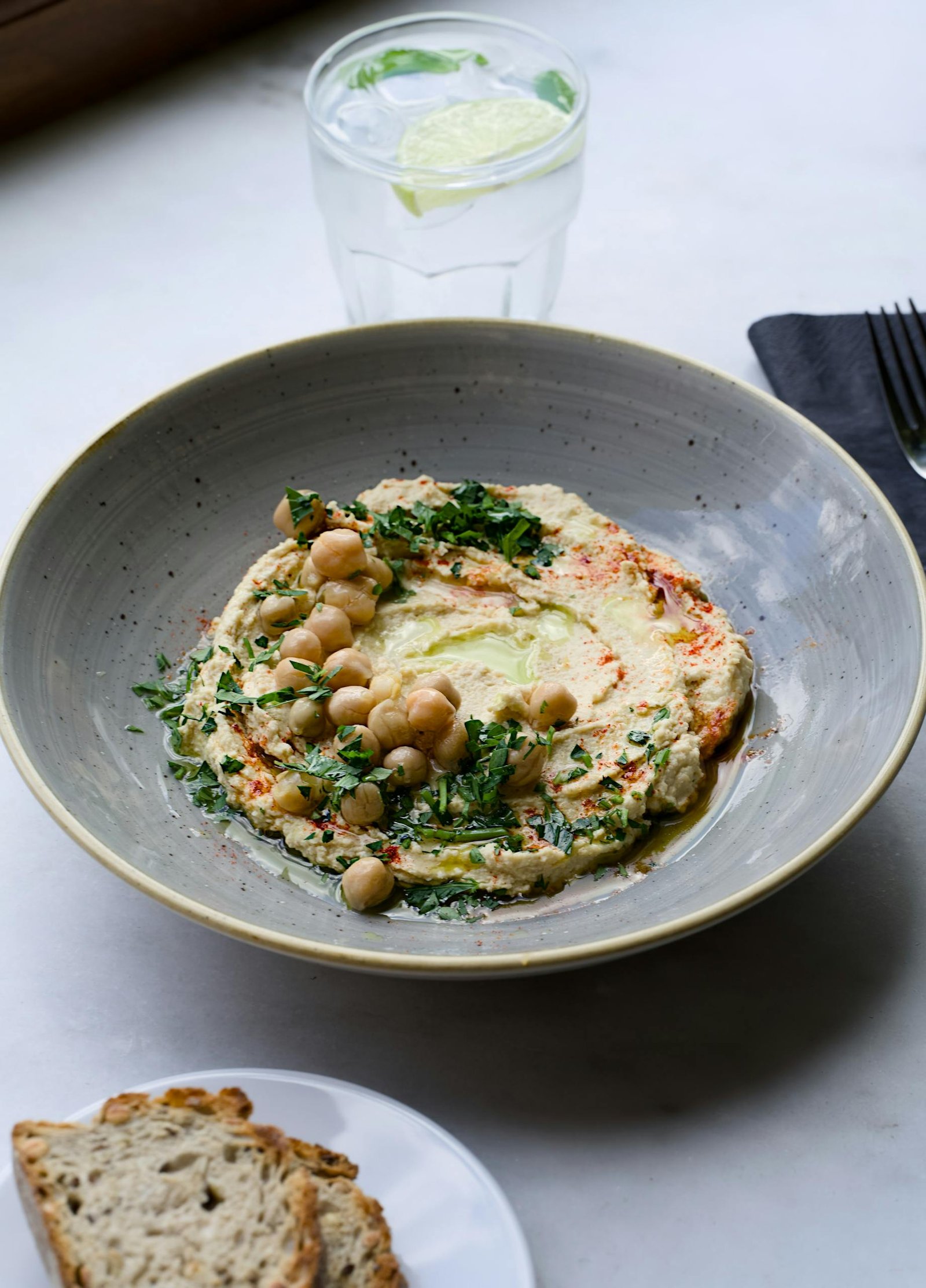 A close-up of hummus topped with chickpeas and herbs, perfect for a healthy snack.