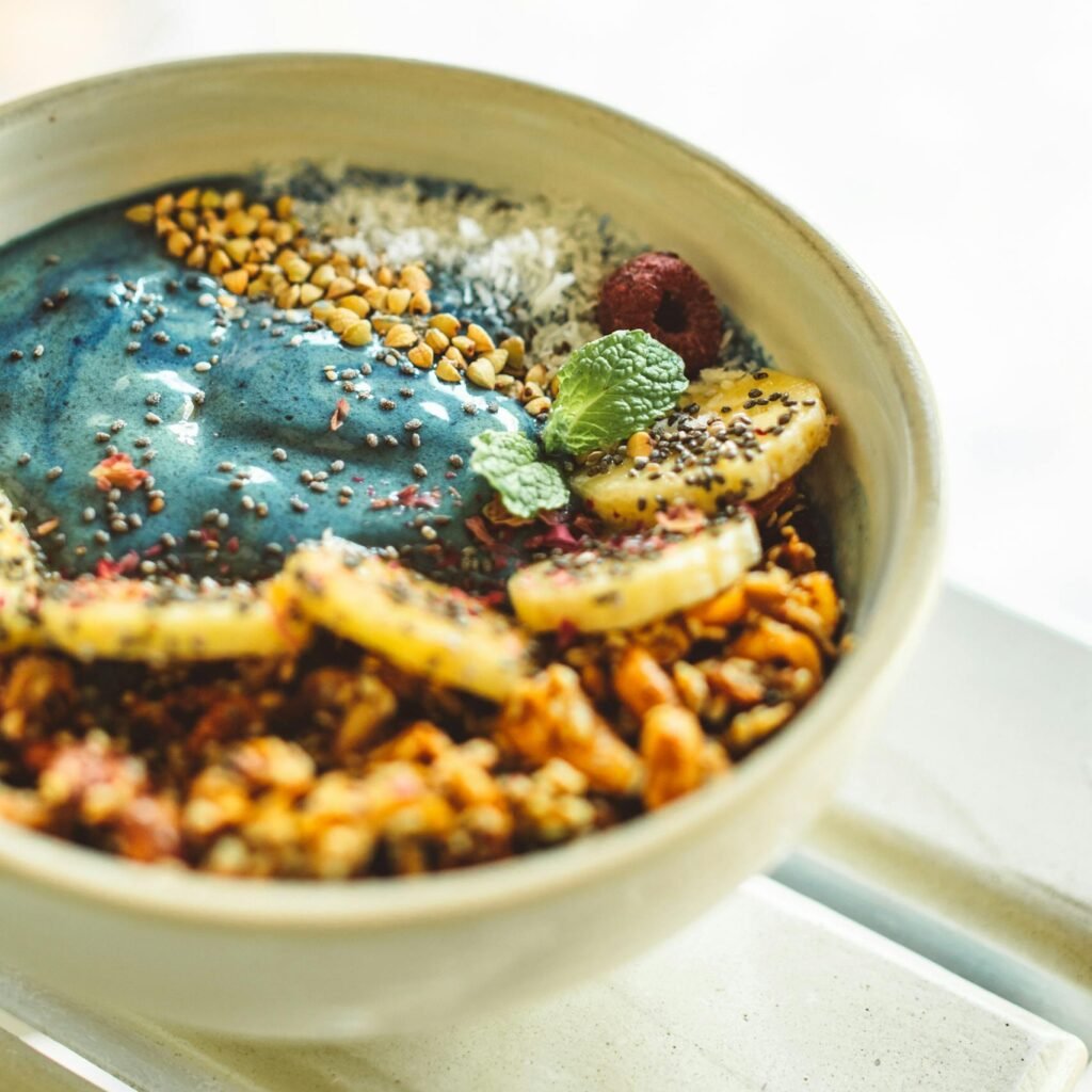 Vibrant and nutritious smoothie bowl topped with banana, seeds, and mint for a healthy breakfast.