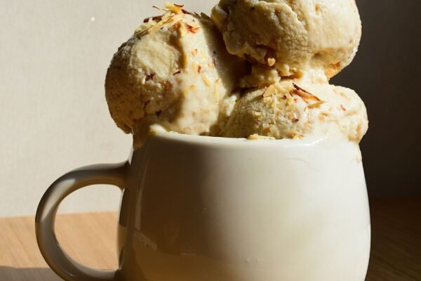 Delicious ice cream in a ceramic mug on a wooden table, perfect for dessert lovers.