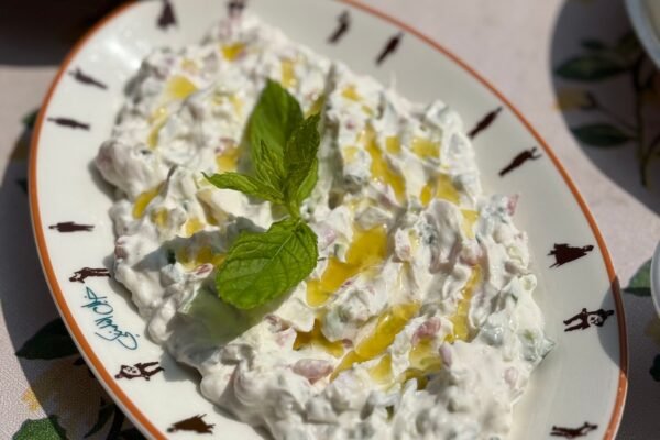 Delicious creamy tzatziki garnished with fresh mint and olive oil, perfect for a summer meal.