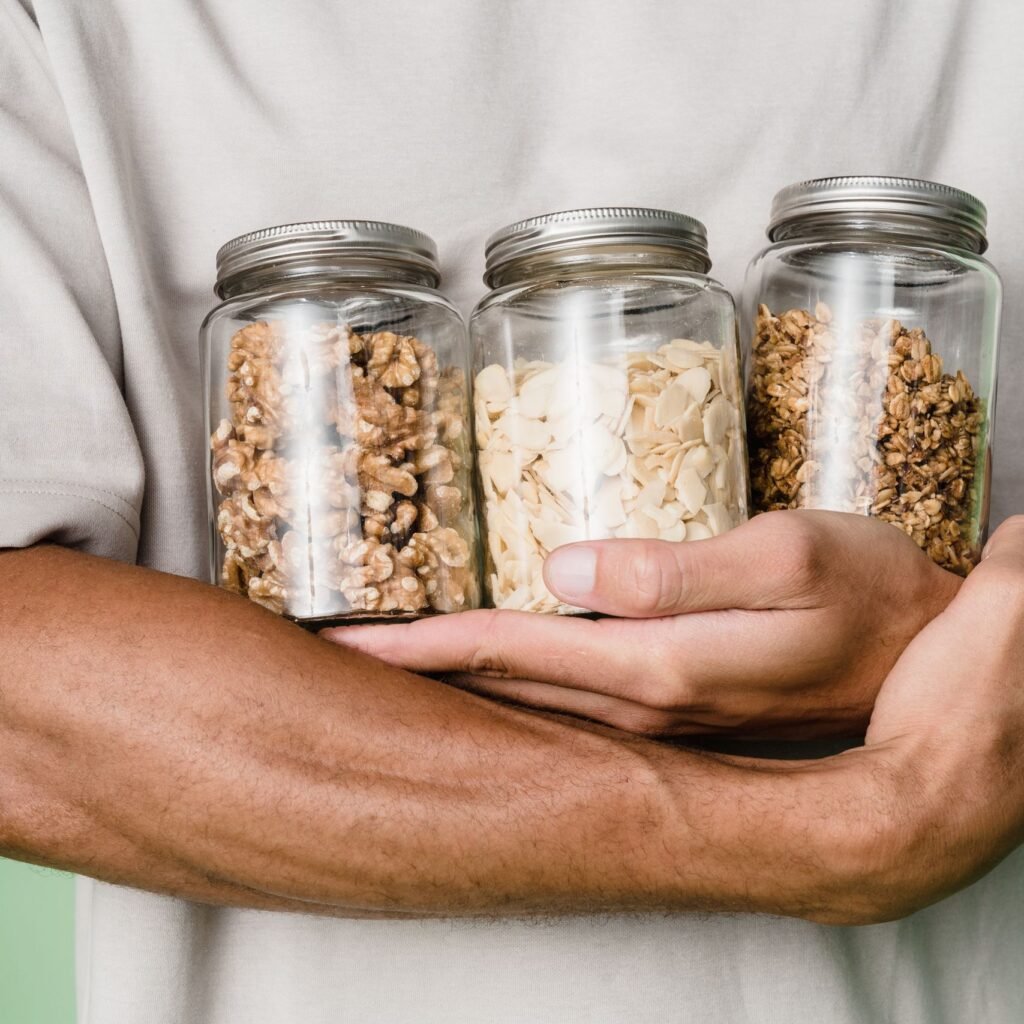 Man holding glass jars filled with nuts, highlighting eco-friendly food storage.