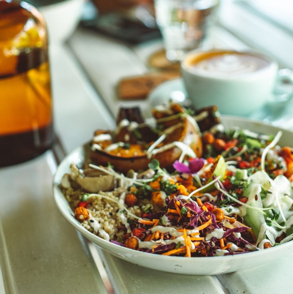 Vibrant vegan salad with diverse vegetables on a cafe table, perfect for a healthy lunch.